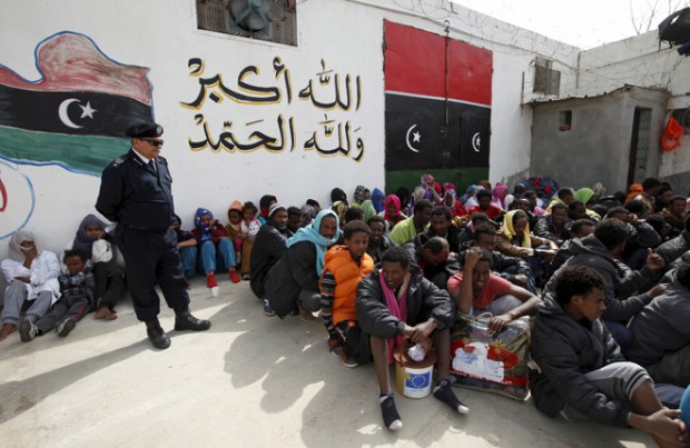 Illegal migrants sit at Abu Saleem detention center in Tripoli