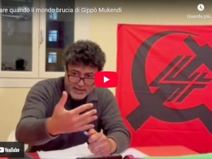 Gippò Mukendi con bandiera Quarta Internazionale